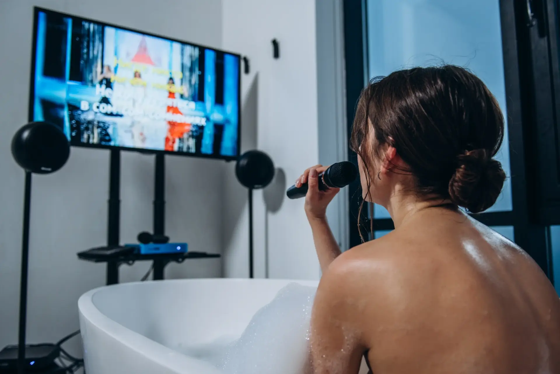 Woman singing karaoke in a bathtub