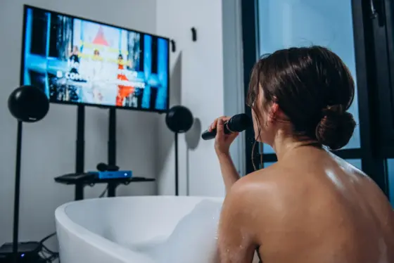 Woman singing karaoke in a bathtub