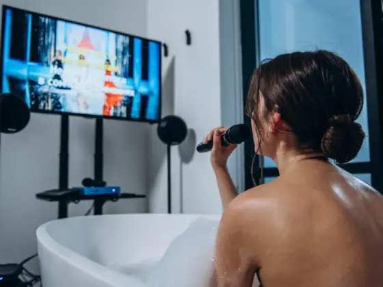 Woman singing karaoke in a bathtub