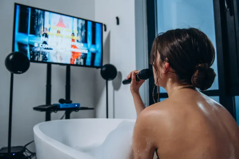 Woman singing karaoke in a bathtub