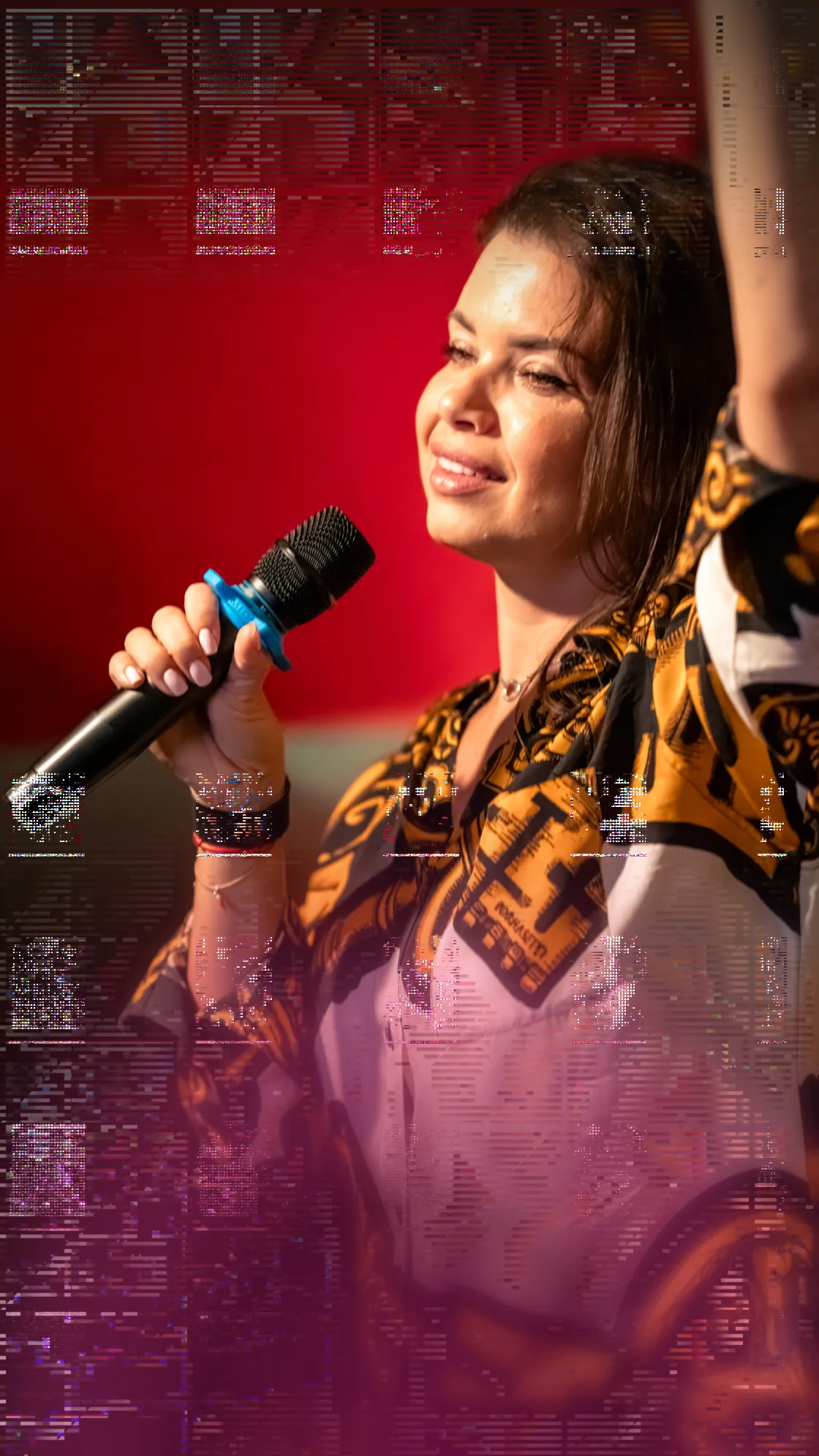 Mujer cantando al micrófono en un escenario con luz roja