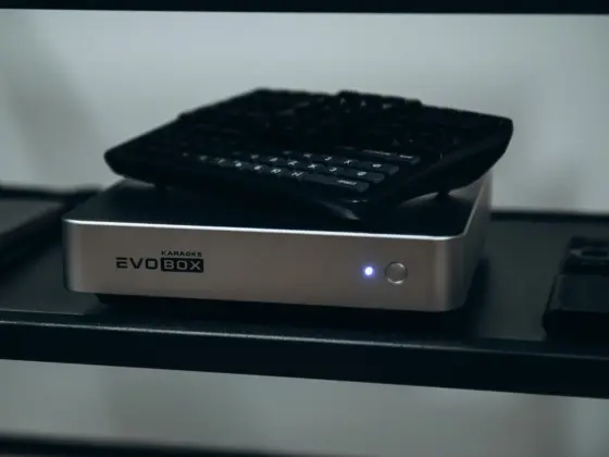 EVOBOX karaoke system with a wireless keyboard and remote on a shelf