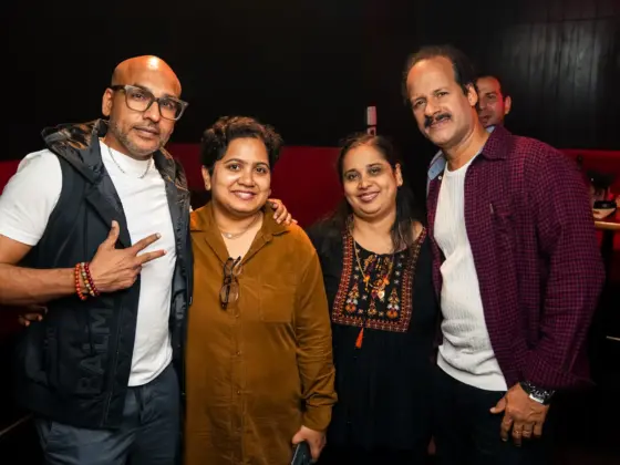 Friends and relatives smiling and posing for a photo in a karaoke room